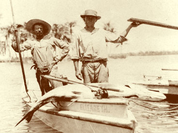 Speed Menefee (Naples first mayor) on left with Aldman (guide) standing in shallow fishing boat 