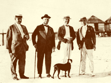 Pictured L to R: Walter Parmer, unidentified man, John Hachmeister and another unidentified man with dog standing on Naples beach with pier in background. (John Hachmeister Collection)