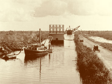 Dipper dredge, drill barge and service boat belonging to R.C. Hoffman Co. working in canal about 30 miles west of Miami during the construction of the Tamiami Trail.  Dated 1926-7.